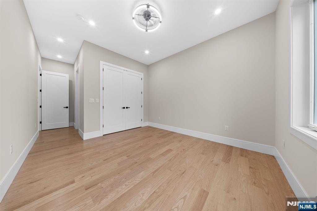 317 Edstan Way Paramus, NJ 07652 - Photo 17 of 48 an empty room with wooden floor and windows