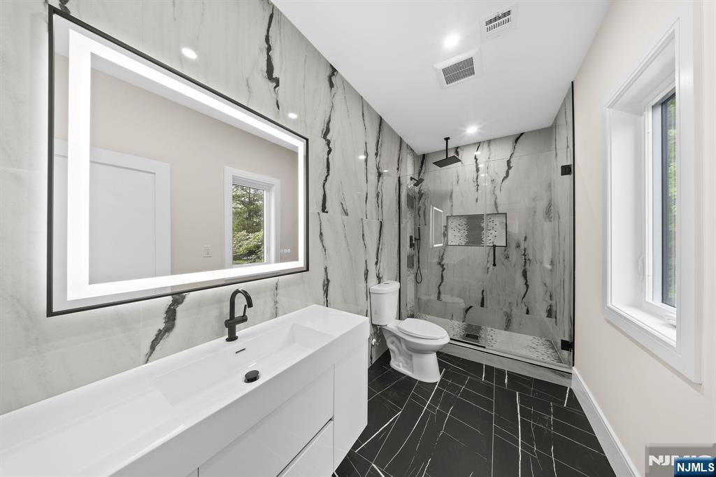 317 Edstan Way Paramus, NJ 07652 - Photo 28 of 48 a bathroom with a double vanity sink toilet mirror and shower