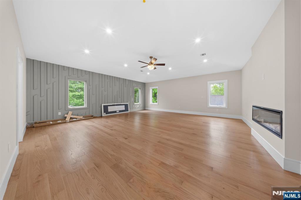 317 Edstan Way Paramus, NJ 07652 - Photo 32 of 48 an empty room with wooden floor fireplace and windows