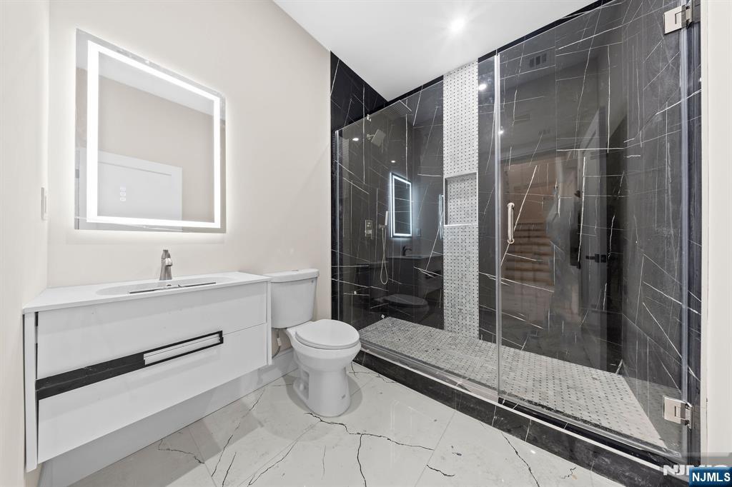 317 Edstan Way Paramus, NJ 07652 - Photo 40 of 48 a bathroom with a toilet sink a mirror and shower