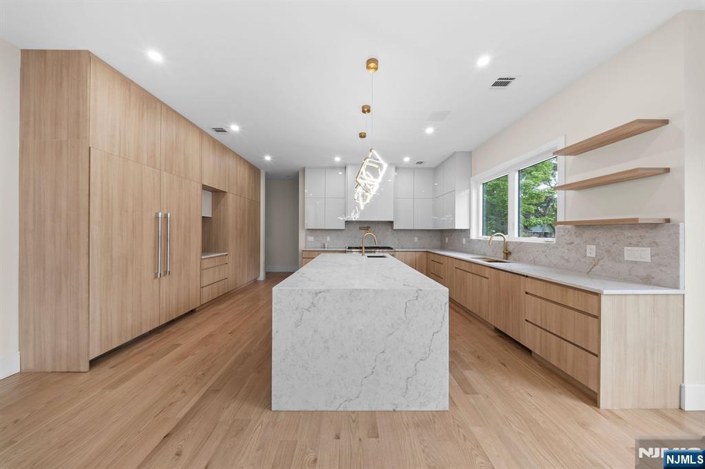 317 Edstan Way Paramus, NJ 07652 - Photo 6 of 48 a large kitchen with stainless steel appliances kitchen island a large counter top and a wooden floors