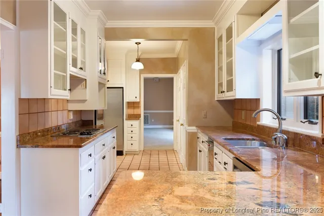 a kitchen with granite countertop white cabinets and a window