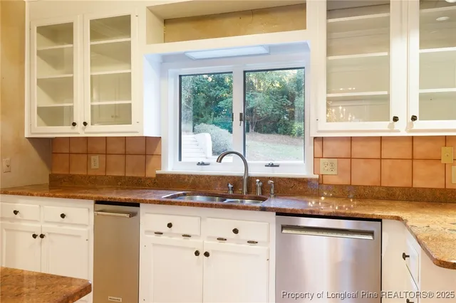 a kitchen with granite countertop a sink and a refrigerator