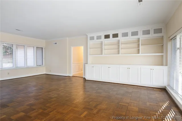 an empty room with cabinet and windows