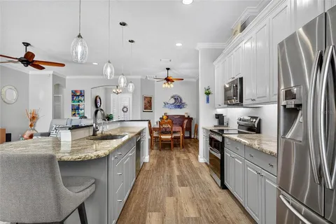 a kitchen with kitchen island granite countertop lots of counter top space and stainless steel appliances