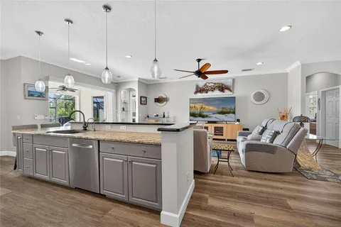 a large kitchen with cabinets and a wooden floor
