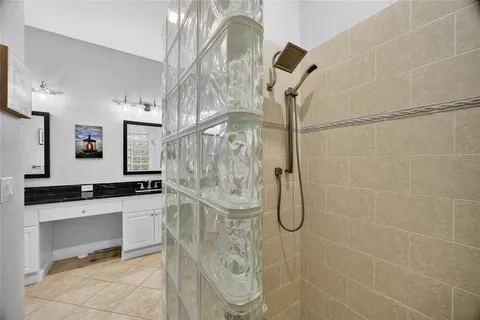 a bathroom with a granite countertop shower a sink and a mirror