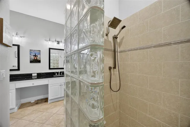 a bathroom with a granite countertop shower a sink and a mirror