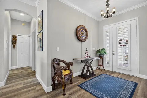a view of a hallway with wooden floor and a chandelier