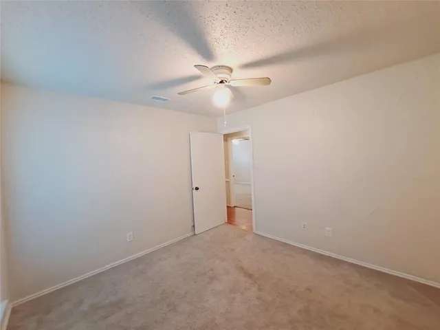 an empty room with a ceiling fan and a fan
