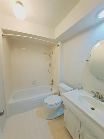 a bathroom with a granite countertop sink a toilet and a bathtub