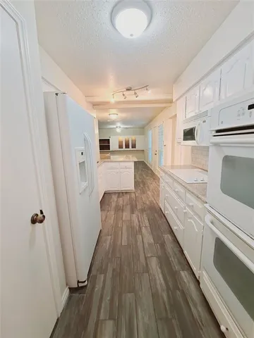 a view of a kitchen with wooden floor and electronic appliances