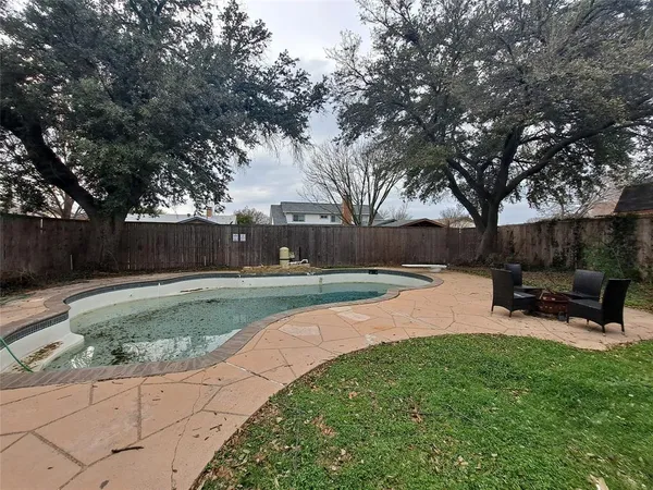 a swimming pool with outdoor seating and garden