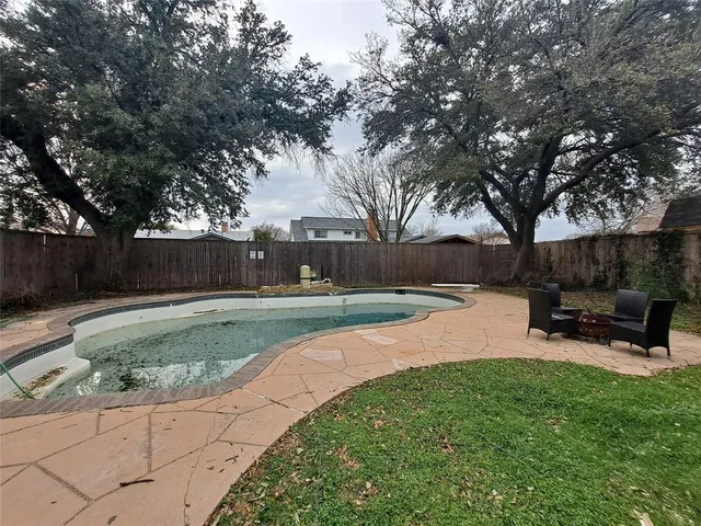 a swimming pool with outdoor seating and garden