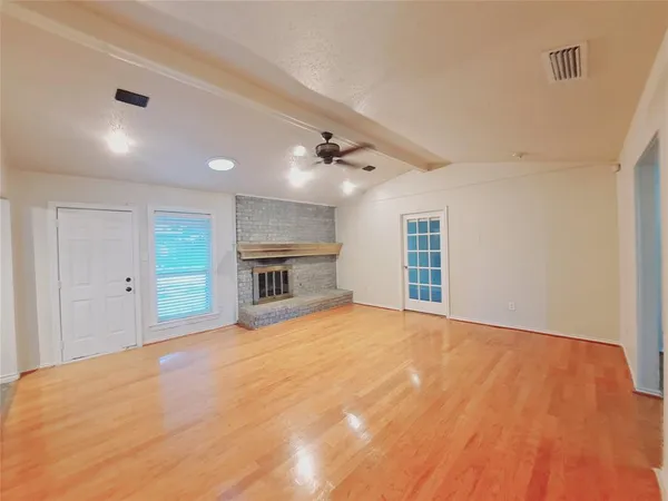 a view of an empty room with a fireplace and a window