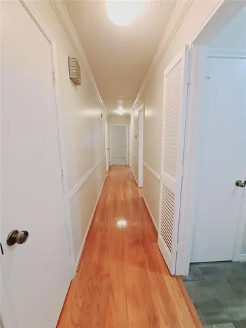 a view of a hallway with wooden floor