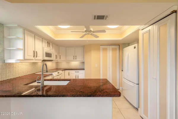 a view of an empty room with window and chandelier fan
