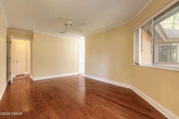an empty room with wooden floor and windows