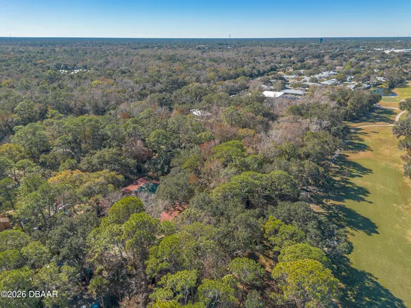an aerial view of residential houses with outdoor space and trees