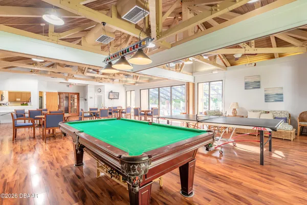 a room with pool table and windows
