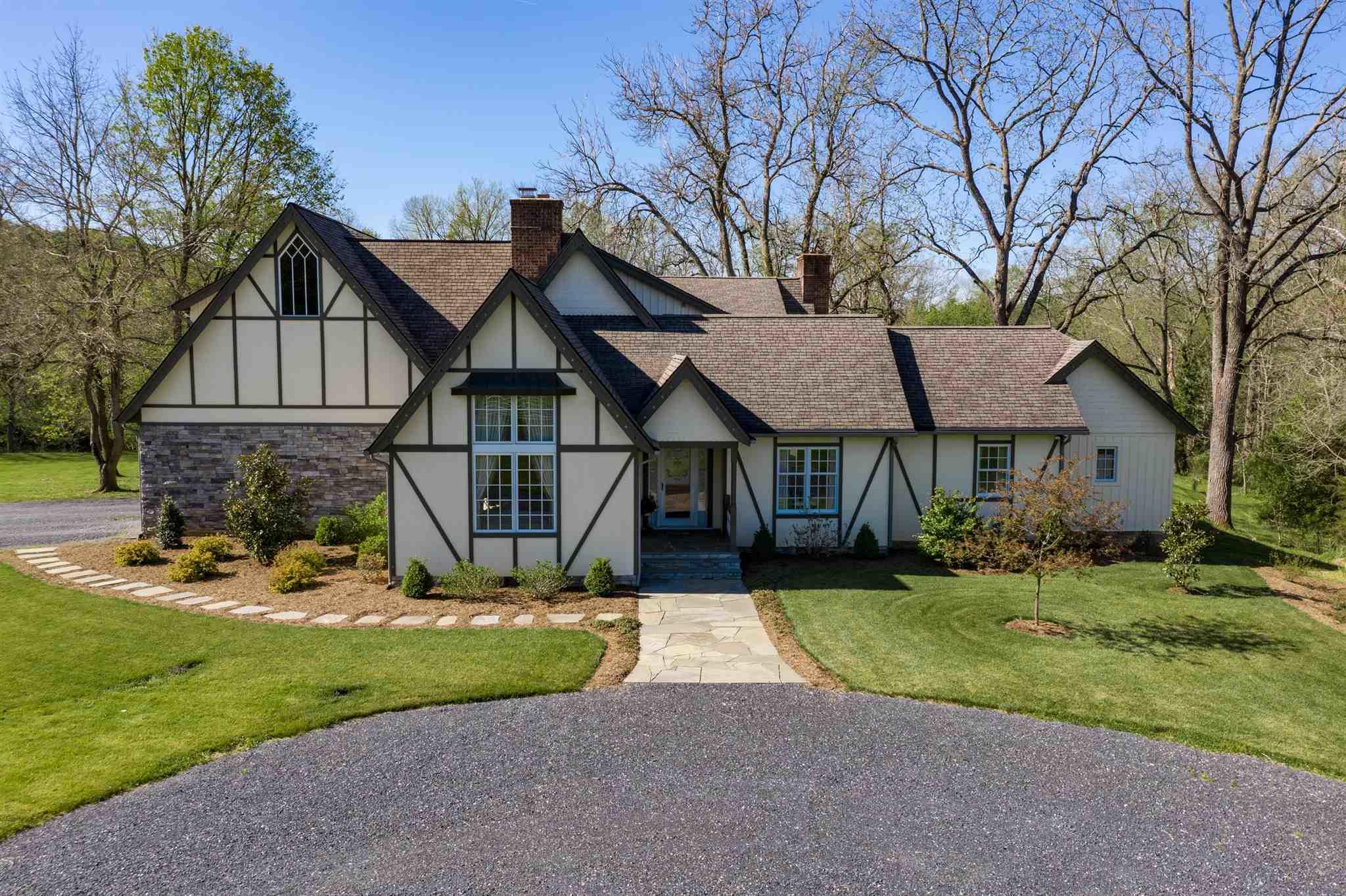 a view of a house with a big yard and large trees