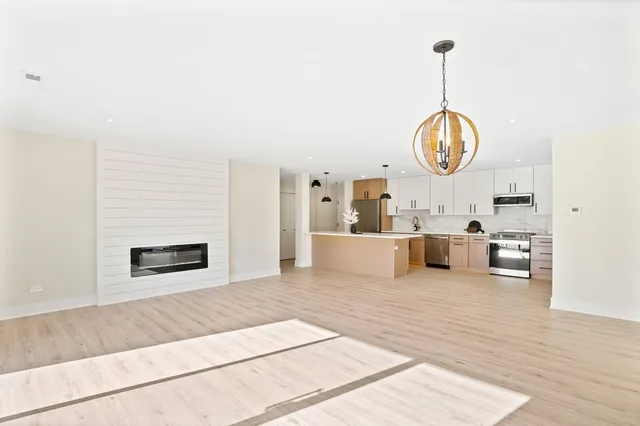 a living room with furniture chandelier and a fireplace