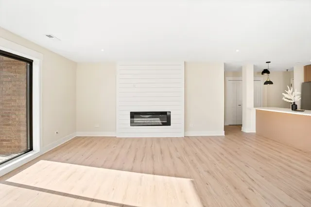a view of a room with wooden floor and a fireplace