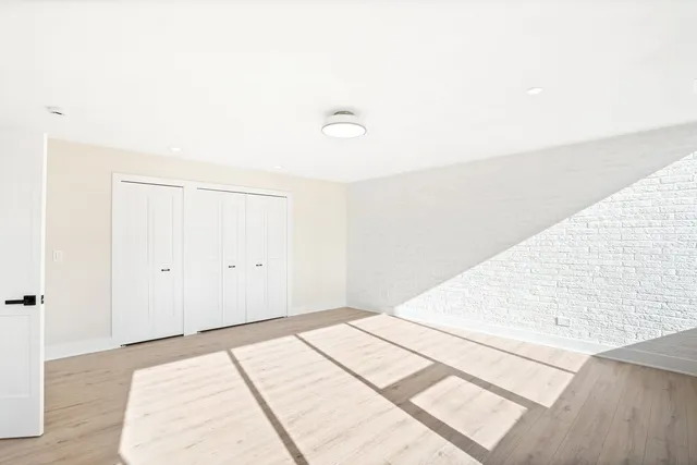 a bedroom with a bed and a wooden floor