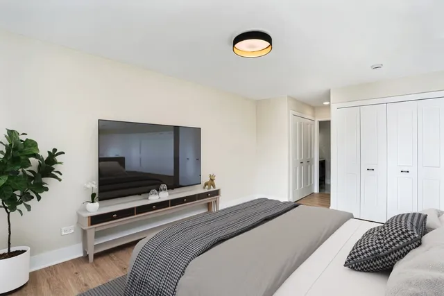 a bedroom with a bed and a potted plant