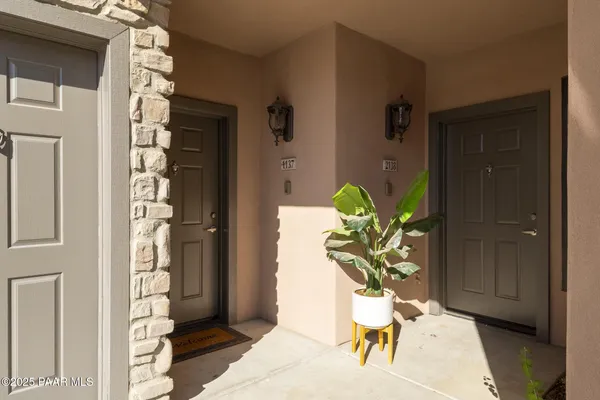a vase of flowers sitting on a floor in front of a door