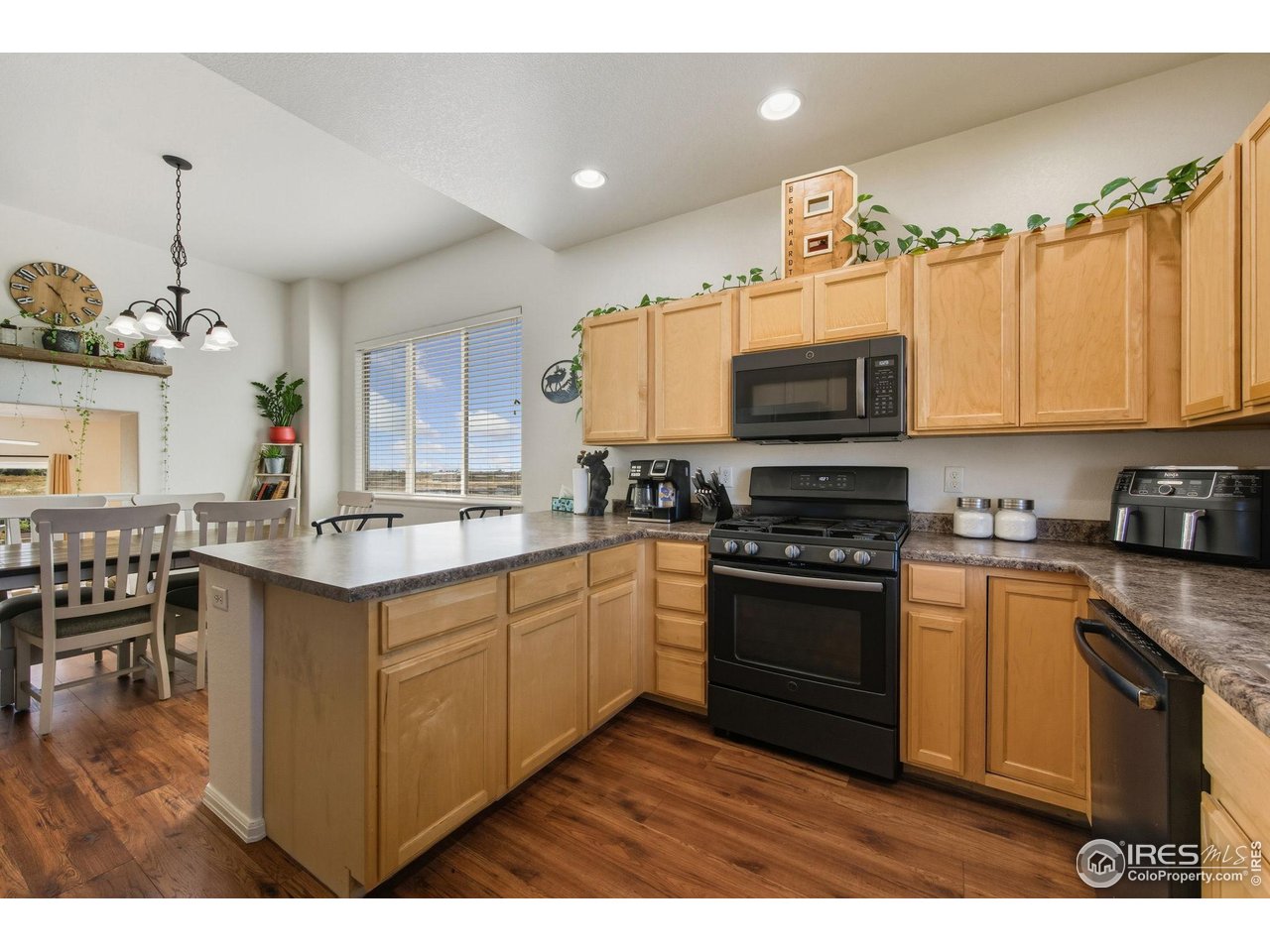 1204 5th Street Pierce, CO 80650 - Photo 8 of 44 a kitchen with stainless steel appliances granite countertop a stove top oven a sink dishwasher and a microwave oven with cabinets