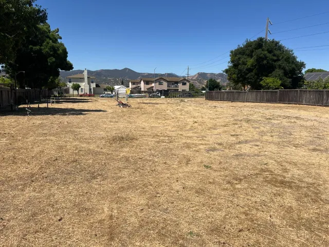 a view of swimming pool with outdoor seating and trees in the background