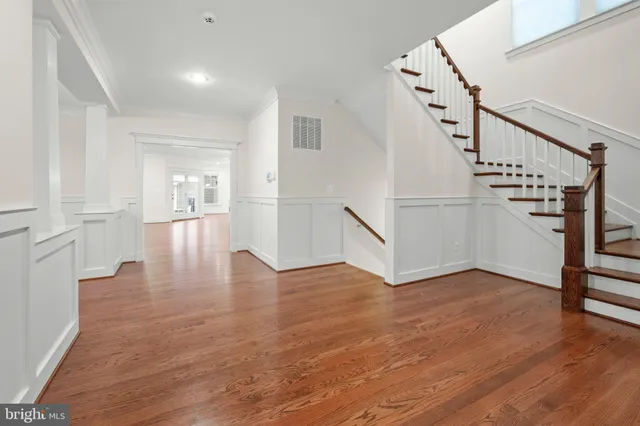a living room with stainless steel appliances furniture a rug and a fireplace