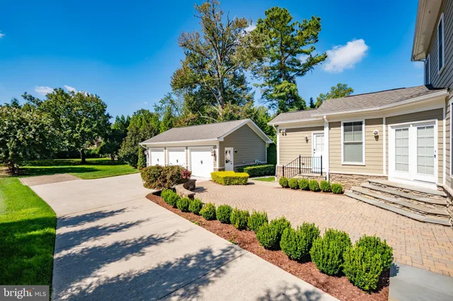a front view of a house with a yard and potted plants
