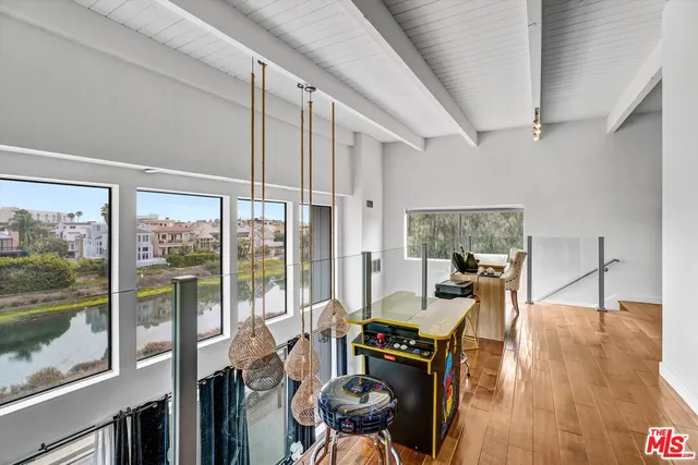 a living room with furniture large window and wooden floor