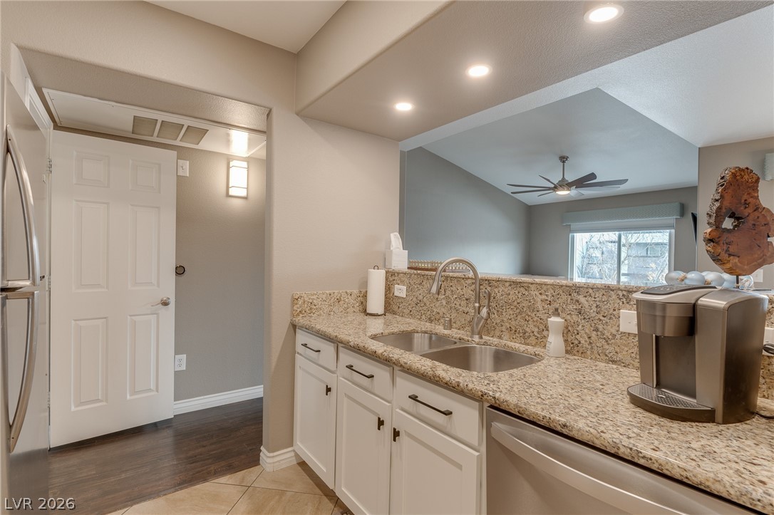 7255 West Sunset Road, Unit 2155 Las Vegas, NV 89113 - Photo 11 of 21 Kitchen featuring light stone countertops, white cabinets, appliances with stainless steel finishes, ceiling fan, and light tile patterned floors