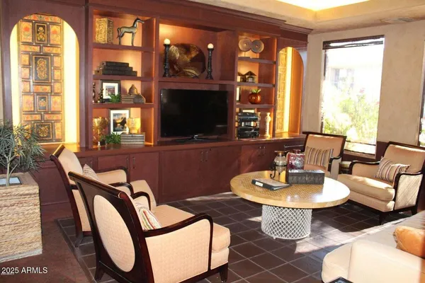 a living room with patio furniture and a flat screen tv