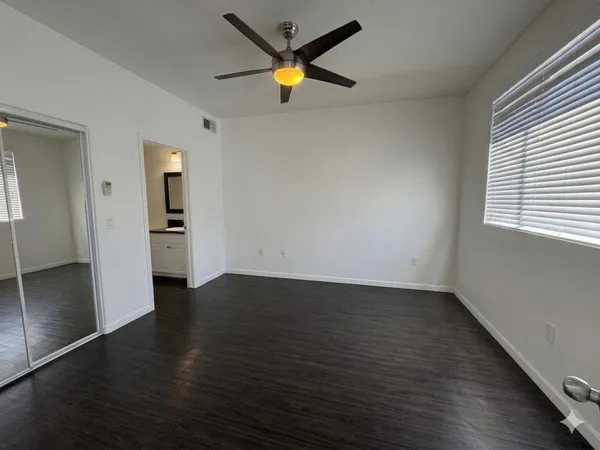 an empty room with wooden floor and a window
