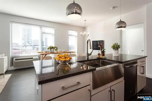 a kitchen with a sink a counter top space a stove and a window