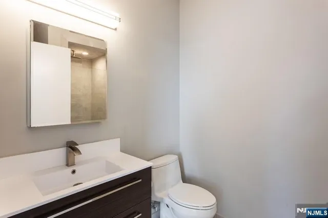 a bathroom with a sink a toilet and mirror