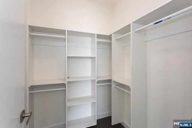 a view of walk in closet with empty racks