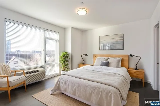 a bedroom with a bed and a couch next to a window