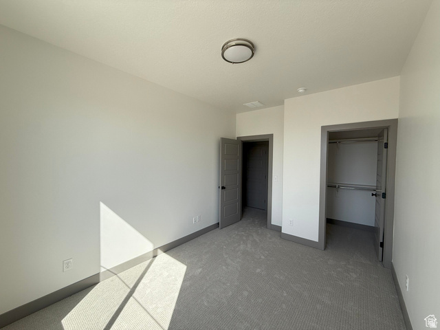 8087 South 615 East, Unit 3 Sandy, UT 84070 - Photo 15 of 23 Carpeted room featuring a ceiling-mounted light fixture, white walls, and contrasting gray trim