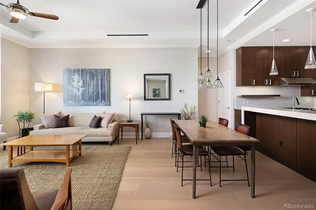 a living room with furniture a flat screen tv and kitchen view