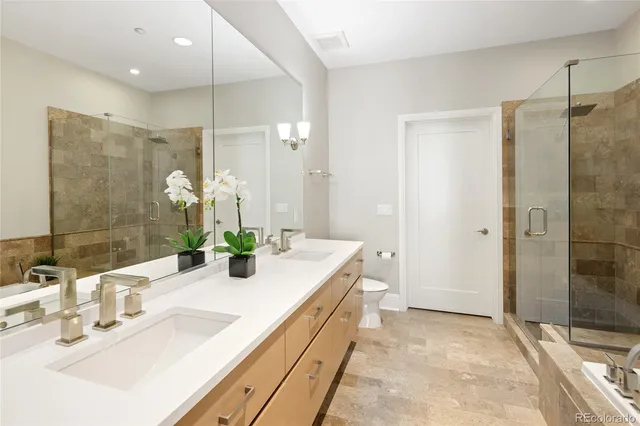 a bathroom with a double vanity sink mirror and shower