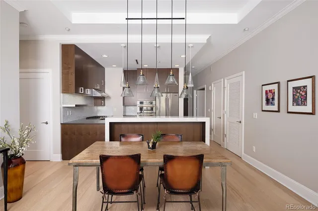 a kitchen with stainless steel appliances kitchen island granite countertop a table chairs in it and wooden floors