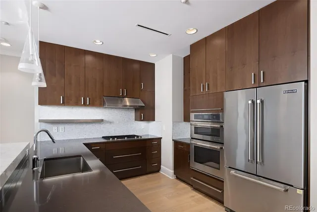 a kitchen with granite countertop stainless steel appliances and wooden cabinets