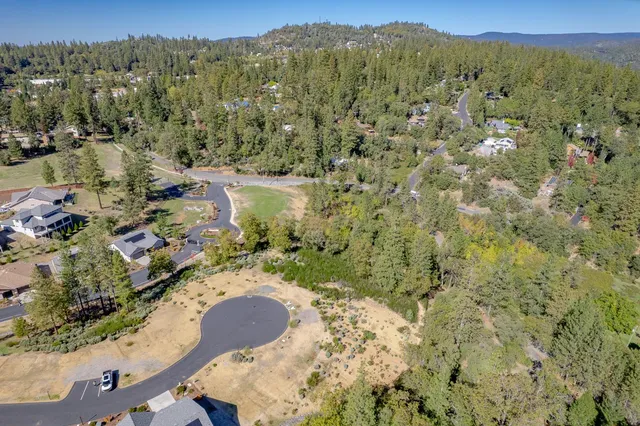 an aerial view of a swimming pool with outdoor seating and yard