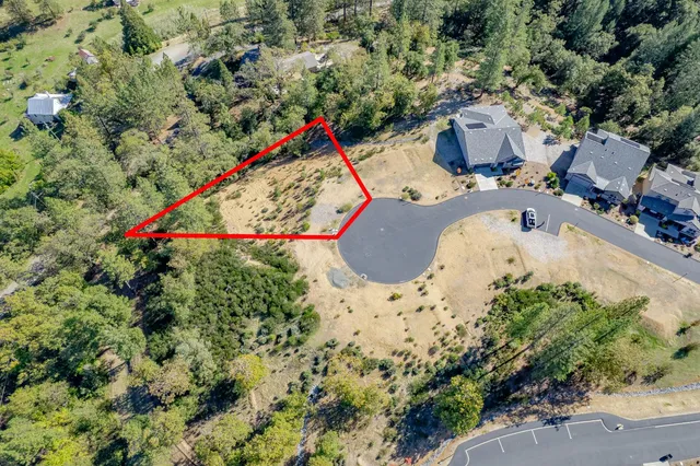 an aerial view of a house with a yard and sitting area