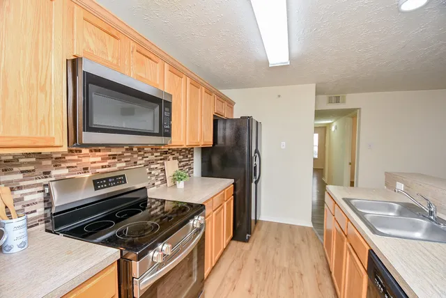a kitchen with stainless steel appliances a stove a sink and a microwave